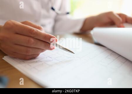 Femme professionnelle médecin regardant le cardiogramme pour analyser les résultats Banque D'Images