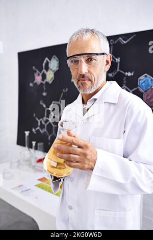 Décomposition de la chimie. Portrait d'un scientifique mâle mature faisant une expérience de chimie dans son laboratoire. Banque D'Images