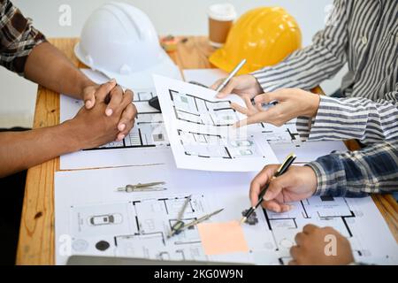 Équipe d'ingénieurs de construction et d'architectes asiatiques professionnels discutant, vérifiant le plan et travaillant ensemble dans le bureau. Gros plan mains i Banque D'Images