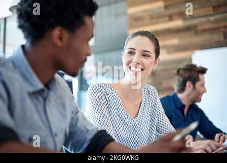 Connexions de bureau positives. Femme d'affaires confiante ayant une conversation positive avec un collègue dans une salle de réunion. Banque D'Images