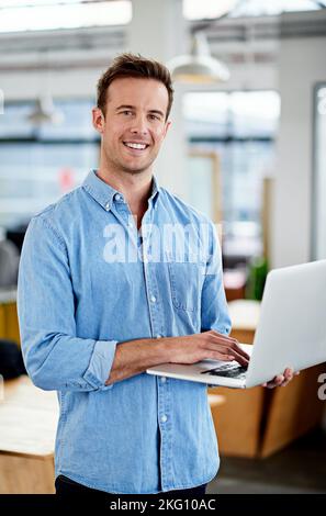 Une entreprise innovante. Un homme travaillant sur un ordinateur portable dans un bureau. Banque D'Images