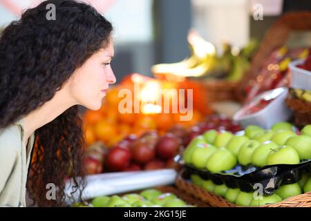 Gros plan d'une femme choisissant des légumes dans une greengrocery Banque D'Images