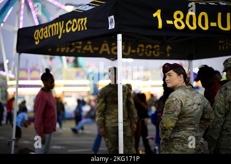 Un soldat regarde tandis que les amateurs de foire apprécient leur soirée à la foire de l'État de Caroline du Sud vendredi. Nous tenons à remercier tous ceux qui se sont arrêtés pour passer du temps avec nous alors que le soleil se couche sur nos derniers jours à la foire de l'État de Caroline du Sud! J'espère que tout le monde en a appris un peu plus sur notre équipe de l'Armée de terre, y compris la Réserve de l'Armée de terre, et sur toutes les possibilités que nous avons à offrir. Nous avons apprécié la construction de la camaraderie avec notre communauté de Caroline du Sud! Photo de l'armée américaine par le sergent d'état-major. Crystal Harlow Banque D'Images