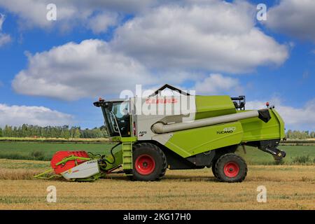Agriculteur travaillant dans les champs avec la moissonneuse-batteuse Claas Tucano 430 APS récoltant le grain par une journée claire de l'automne. Ilmajoki, Finlande. 11 août 2018. Banque D'Images