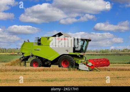 Agriculteur travaillant dans les champs avec la moissonneuse-batteuse Claas Tucano 430 APS récoltant le grain par une journée claire de l'automne. Ilmajoki, Finlande. 11 août 2018. Banque D'Images
