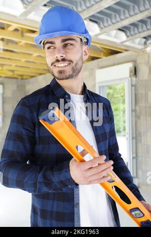 homme de construction à barbe confiant portant une combinaison et un casque robuste debout Banque D'Images