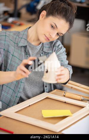 charpentier féminin attrayant utilisant quelques outils dans son atelier Banque D'Images