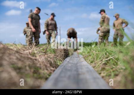 Un Airman de la Force aérienne des États-Unis affecté au 18th Logistics Readiness Squadron fait rouler une section de tuyau de 100 pieds pendant les acquisitions pour l'équipe du point de ravitaillement de la zone de l'avant de la base aérienne de Kadena, au Japon, le 21 octobre 2022. Les aviateurs ont été chargés de mener une configuration et une dépanne chronométrées de la FARP, suivies d'un ensemble d'exercices d'endurance. Banque D'Images