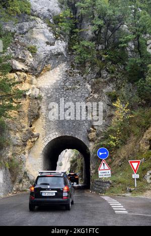 Voitures entrer dans le tunnel étroit de route à fichier unique à travers les falaises ou les affleurements rocheux de la gorge du Verdon Rougon Alpes-de-haute-Provence France Banque D'Images