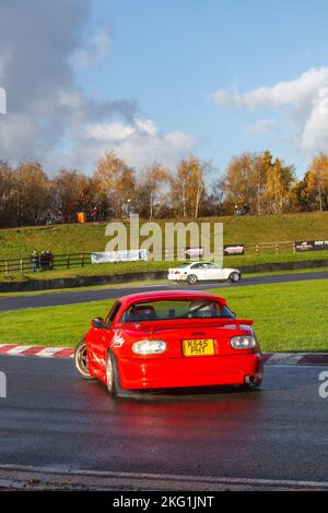 1993 Rouge MAZDA MX-5 1600cc essence manuelle à 5 vitesses 90s, années 90 voiture à propulsion arrière, conduite sur des pistes de dérive et virages à grande vitesse sur des routes humides lors d'une journée de la dérive des trois Sœurs à Wigan, au Royaume-Uni Banque D'Images