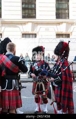 Des membres de Southern Highlanders Pipes & Drums discutent avant de diriger le défilé commémoratif annuel des veuves de guerre. Whitehall court, Londres, Royaume-Uni Banque D'Images