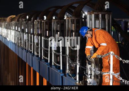 (221121) -- SHANGHAI, le 21 novembre 2022 (Xinhua) -- Un travailleur vérifie la levée de l'épave du Yangtze no 2 sur le site d'opération de sauvetage de Shanghai, en Chine orientale, le 21 novembre 2022. Un ancien naufrage, l'un des plus grands et des plus préservés naufrages en bois découverts sous l'eau en Chine à ce jour, a été soulevé hors des eaux à Shanghai début lundi. L'épave du Yangtze no 2 remonte au règne de l'empereur Tongzhi (1862-1875) de la dynastie Qing. Cette récupération pourrait offrir un aperçu utile de la technologie de la construction navale pendant la dynastie Qing. Un jalon dans l'eau de la Chine a Banque D'Images