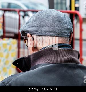 Epsom, Surrey, Londres, Royaume-Uni, 19 novembre 2022, homme âgé coup de tête de derrière portant Une casquette plate et des lunettes traditionnelles Banque D'Images