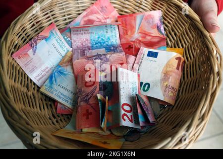 Église Saint Bernard-de-Menthon. Collection pendant une messe catholique. Panier en francs suisses et en euros. Suisse. Banque D'Images