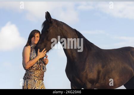 jeune femme avec jument de friesian Banque D'Images