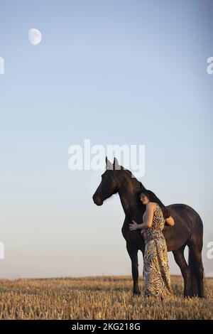 jeune femme avec jument de friesian Banque D'Images