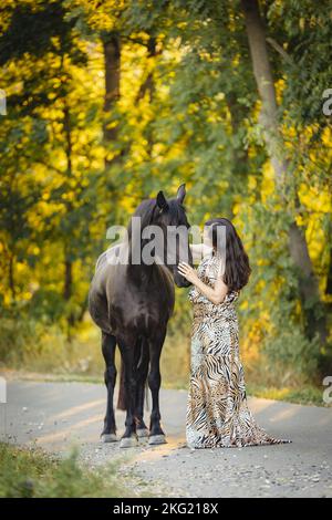 jeune femme avec jument de friesian Banque D'Images