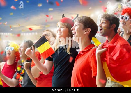 Fan de football belge au stade. Les supporters belges regardent le football en plein air. Les fans de l'équipe qui applaudissent célèbrent la victoire. Allez aux Red Devils ! Banque D'Images