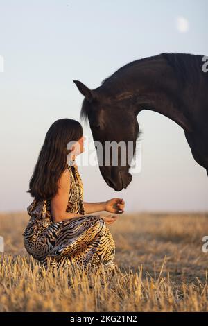 jeune femme avec jument de friesian Banque D'Images