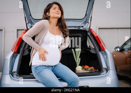 Future mère sensation de douleur dans l'abdomen ventre pendant les achats de maternité. Banque D'Images