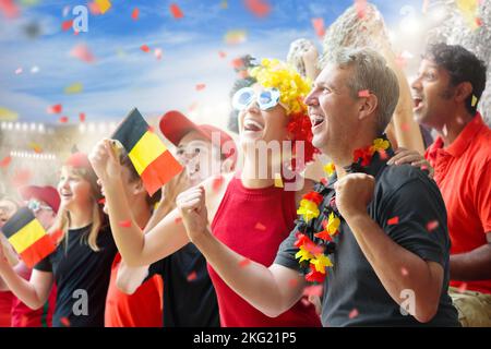 Fan de football belge au stade. Les supporters belges regardent le football en plein air. Les fans de l'équipe qui applaudissent célèbrent la victoire. Allez aux Red Devils ! Banque D'Images