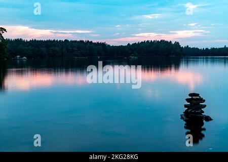 Le ciel nuageux sur le lac calme capturé au coucher du soleil Banque D'Images