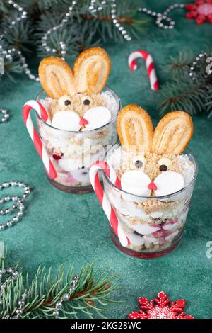 Gâteau sans cuisson sous la forme de lapins mignons dans deux verres avec des cerises, des biscuits et de la crème caillé. Symbole de la nouvelle année 2023 Banque D'Images