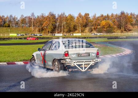 BMW série 3 modifiée en blanc gris ; sport automobile personnalisé HYC ; voiture à propulsion arrière, conduite sur pistes de dérive et virages à grande vitesse sur routes humides lors d'une journée des trois sœurs de la dérive à Wigan, au Royaume-Uni Banque D'Images