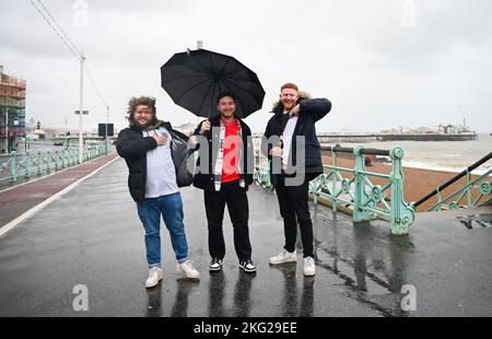 Brighton UK 21st novembre 2022 - les fans d'Angleterre combattent le vent et la pluie sur le front de mer de Brighton en faisant leur chemin à un bar pour regarder le match de la coupe du monde du Qatar entre l'Angleterre et l'Iran aujourd'hui : Credit Simon Dack / Alamy Live News Banque D'Images