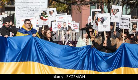 Halifax, Canada. 19th novembre 2022. Les manifestants tiennent des pancartes et un grand drapeau ukrainien lors d'un rassemblement pour soutenir les populations en Iran et en Ukraine. Les gens de Halifax se sont rassemblés samedi au parc de la paix et de l'amitié pour montrer leur soutien à la population de l'Ukraine et de l'Iran. Des centaines de partisans ont fait des signes et ont appelé à l'action, de l'autre côté de la rue, des leaders de la défense discutant des préoccupations urgentes en matière de sécurité mondiale au Forum international de Halifax sur la sécurité. L'organisateur Reza Rahimi a déclaré qu'il voulait que ces dirigeants entendent leur voix, en particulier parce que tant de personnes vivant dans ces pays ne peuvent pas parler au Banque D'Images