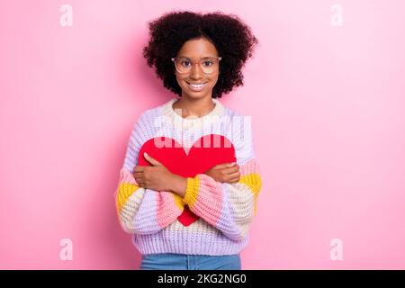 Photo de mignon jeune fille positive écolière robe tricots rug papier rouge coeur premier collège amour isolé sur fond de couleur rose vif Banque D'Images