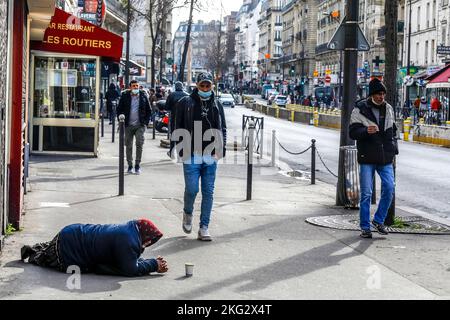 Mendiant couché sur le trottoir à Paris, France Banque D'Images