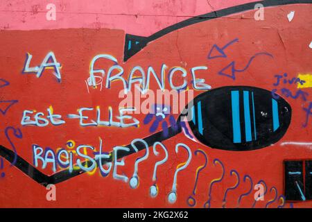 Mur de rue recouvert d'art de rue et de graffiti à Paris, France. 'Les Français sont-ils racistes ?' Banque D'Images