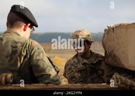 Bryce Henderson, affecté à la compagnie Bravo, 1er bataillon, 12e régiment de cavalerie, 3e brigade blindée équipe de combat, 1re division de cavalerie montre aux soldats polonais de la 1re brigade de Varsovie le char de combat principal Abrams M1A2 SepV3. Cette manifestation faisait partie du sommet des chars d'Abrams et c'était la première fois que ces soldats polonais avaient l'occasion de voir le SepV3. 1ère division de cavalerie, 3ème équipe de combat de brigade blindée, DÉPLOIEMENT, GREYWOLF, Pologne, plus forts ensemble, Banque D'Images