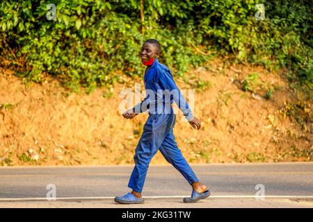 Garçon dans des salopettes marchant à Kigali, au Rwanda Banque D'Images