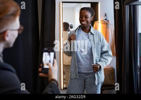 Portrait d'une femme noire souriante portant une tenue en denim et posant pour des photos et des vidéos sur le blog de mode des médias sociaux Banque D'Images