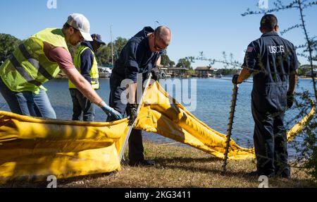 Coast Guardmen et 96th employés du groupe civil Engineer relient des pièces d'un dispositif de confinement de l'huile appelé boom Together le 26 octobre à la base aérienne d'Eglin, en Floride. L'exercice conjoint a testé les efforts de communication de l'unité locale et les réponses à un important déversement de carburant à Weekly. Banque D'Images