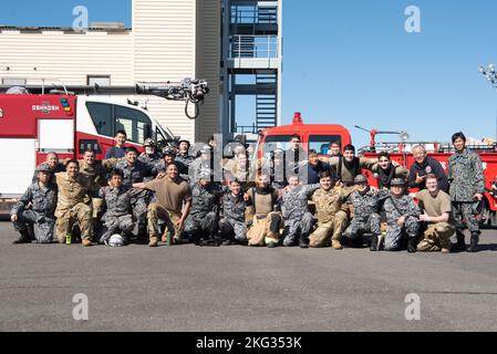 Les pompiers de la Force aérienne japonaise d'autodéfense et de l'escadron du génie civil 374th posent pour une photo de groupe lors d'un entraînement bilatéral à la base aérienne de Yokota, au Japon, le 26 octobre 2022. La pratique de techniques de lutte contre l'incendie standardisées entre les aviateurs américains et japonais a donné aux deux parties l'occasion d'affiner les capacités communes et de construire des partenariats plus solides. Banque D'Images