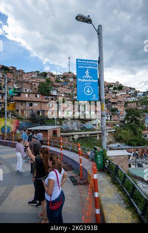 Medellin, Antioquia, Colombie - 13 septembre 2022: Les touristes marchent dans les rues de Comuna 13 par Orange Fences et un signe qui lit "nous sommes en train de construire s Banque D'Images