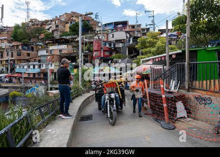 Medellin, Antioquia, Colombie - 13 septembre 2022: Vieux homme, motocycliste, et travailleur de la construction marcher dans la Comuna 13 culturel touristique historique Banque D'Images