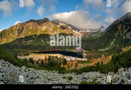 Magnifique lac de montagne Popradske pleso avec ses reflets Forêt d'automne, Hautes Tatras en arrière-plan Banque D'Images