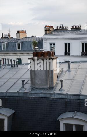 Les toits de zinc avec antennes TV et un groupe de cheminées sous ciel nuageux à Montmartre, Paris, France Banque D'Images