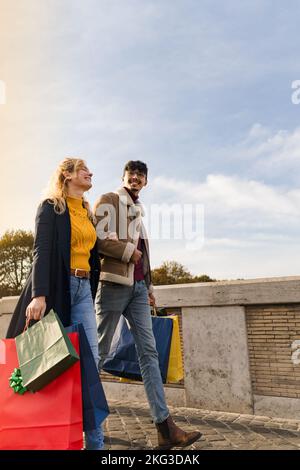 Jeune couple marchant en ville avec des sacs de shopping, du temps de shopping, l'automne et la saison d'hiver Banque D'Images