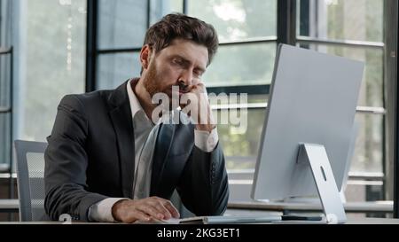 Dormir fatigué paresseux napping yawn adulte barbu homme Manager travailleur s'ennuyer au travail projet en ligne dans l'ordinateur dans le bureau Caucasien mature malade Banque D'Images