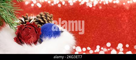 Boules de Noël avec cônes dans sac cadeau en fourrure avec branche de sapin sur fond rouge flou avec bokeh blanc. Bannière, concept de shopping, ventes. Nouvelle année. C Banque D'Images