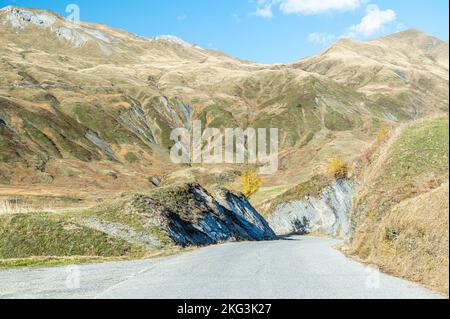 Photo à angle bas d'une route étroite vide entourée de montagnes en Savoie France. Banque D'Images