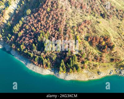 Photo aérienne en perspective d'une terre rurale au-dessus d'un lac avec une forêt dense et des prairies vertes en Europe France. Banque D'Images