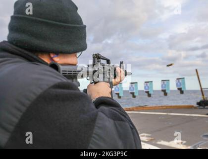 MER DU JAPON (OCT 27, 2022) Ensign Benjamin Freund, d'Old Westbury, New York, tire un fusil de M4 sur le pont de vol lors d'une fusillade d'équipage à bord d'un destroyer à missiles guidés de classe Arleigh Burke USS Benfold (DDG 65), octobre 27. Benfold est affecté au Commandant de la Force opérationnelle (CTF) 71/Destroyer Squadron (DESRON) 15, le plus grand DESRON déployé à l’avant de la Marine et la principale force de surface de la flotte américaine 7th. Banque D'Images