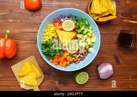 Salade de légumes mexicaine, caviar de cowboy dans un bol avec ingrédients et nachos. Vue de dessus Banque D'Images