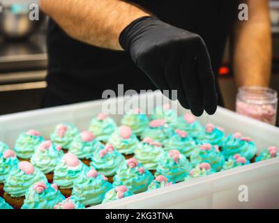 chef pâtissier préparant un bouquet de petits gâteaux givrés sur le thème de la mer turquoise vert Banque D'Images